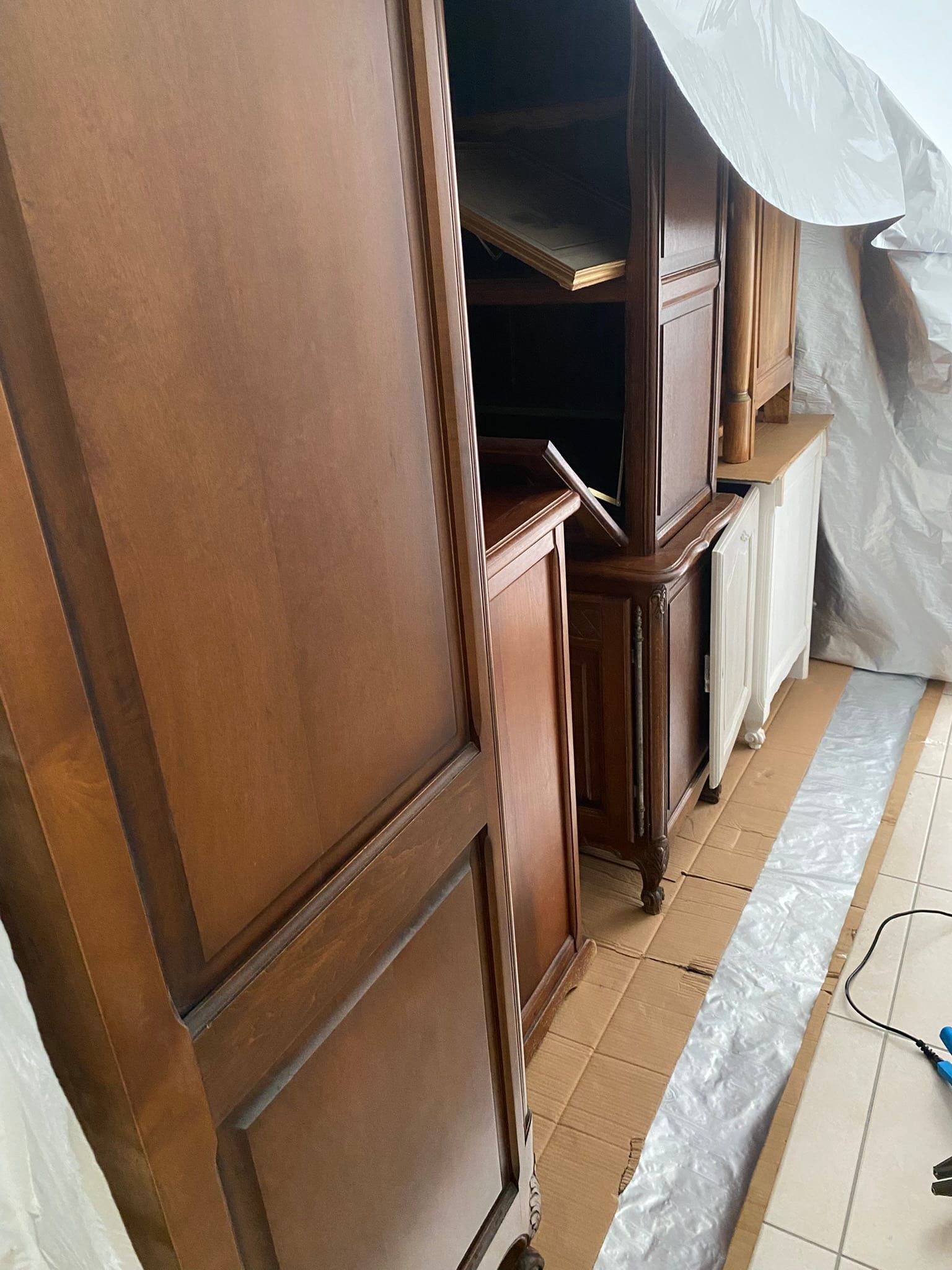 Meubles anciens regroupés sur une bâche avant un traitement par anoxie