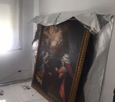 Grand tableau ancien à cadre doré posé contre un mur, partiellement recouvert d’un film barrière aluminium