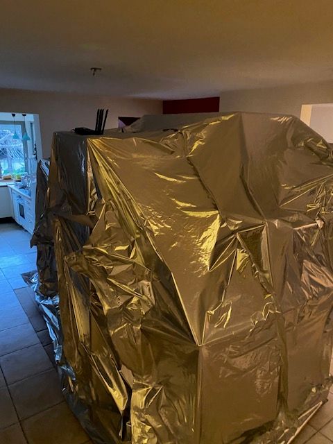 Grande enveloppe étanche en film aluminium fermée dans une pièce de vie, avec le routeur de suivi posé dessus