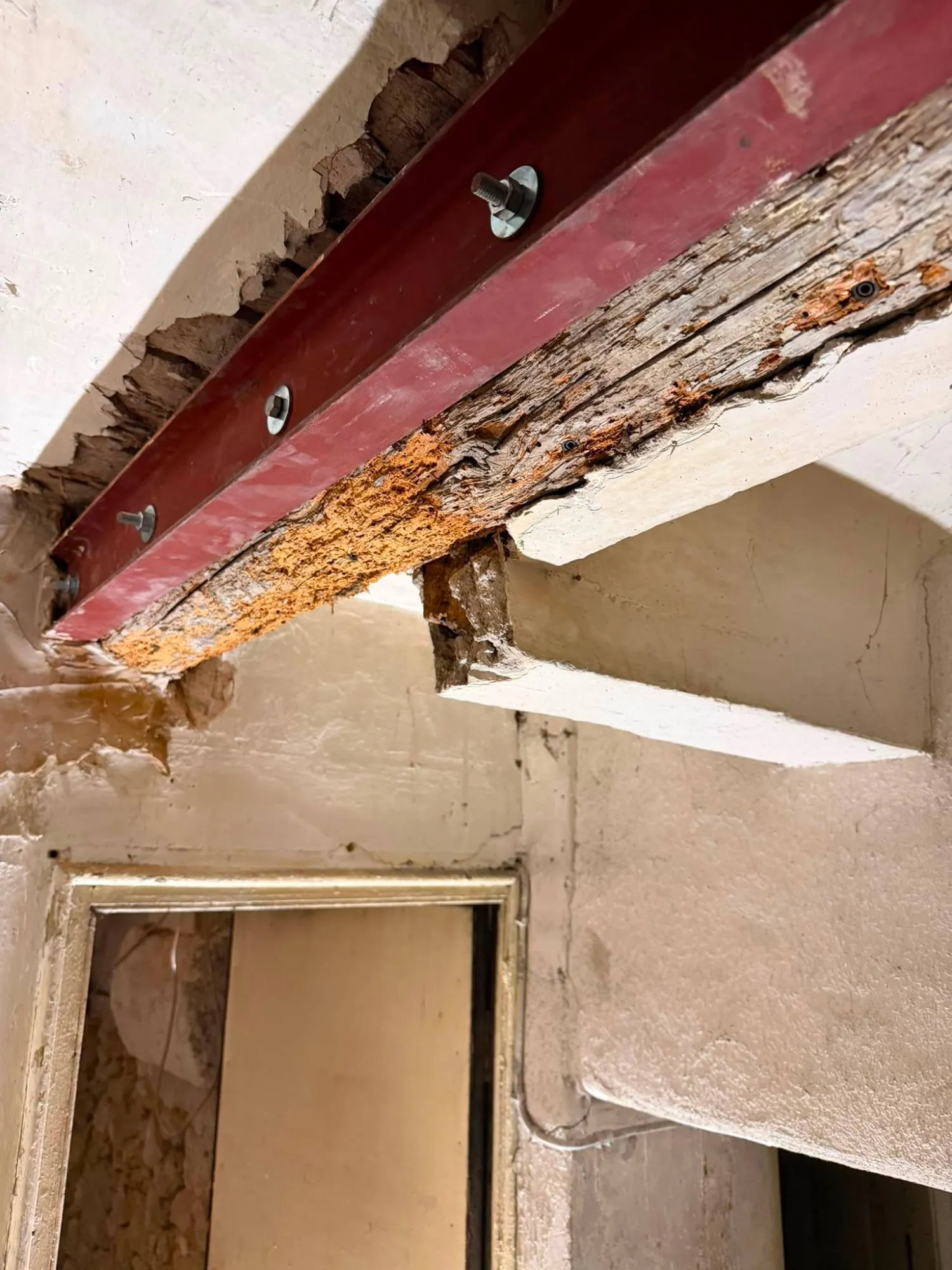 Poutre doublée d’un profilé métallique boulonné au-dessus d’une porte
